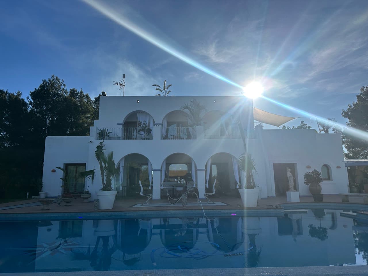 Whitewashed arcaded facade reflected in the swimming pool at Villa Constelacion, Cala Vedella, Ibiza