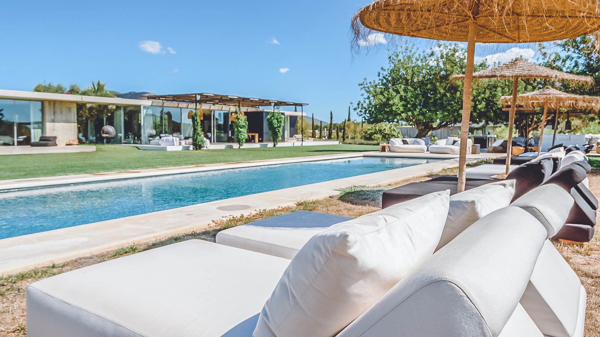 Daybeds shaded by a reed pergola beside the pool at Villa Bianca, Sant Joan de Labritja, Ibiza